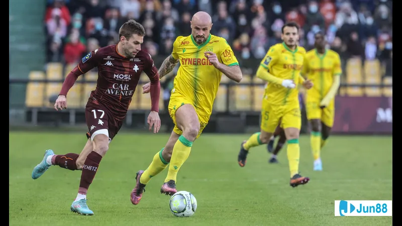 Cầu thủ của Nantes đang vượt qua cầu thủ của Metz trên sân cỏ